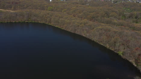 An-aerial-view-of-a-dark-lake-during-a-sunny-day
