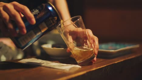 Person-Gießt-Langsam-Dosenbier-In-Ein-Klares-Glas