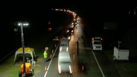 Cola-De-Autos-Conduciendo-En-La-Autopista-Por-La-Noche-Y-Cruzando-La-Frontera-De-Nsw-A-Qld---Puesto-De-Control-Fronterizo-Durante-La-Pandemia-De-Coronavirus-En-Australia