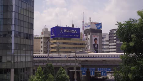 Paisaje-Urbano-Típico-De-Tokio-Con-Calles,-Vías-De-Tren-Elevadas,-Rascacielos-Y-Tren-Bala-De-Alta-Velocidad-Shinkansen-Que-Pasa