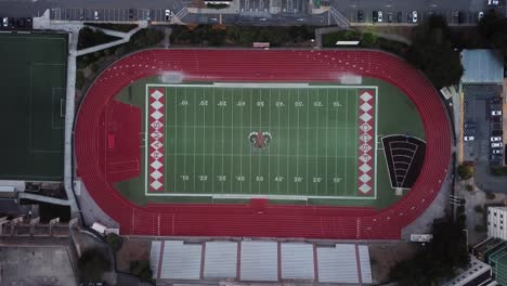 Aerial-view-of-City-college-High-school-football-field-with-a-surrounding-track-of-a-modern-stadium-shot-from-above-with-a-drone