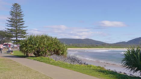 Surfer-With-Surfboard-Walking-On-The-Pathway---Beautiful-Beach-From-The-Crescent-Head-Point-Car-Park---Sydney,-NSW,-Australia