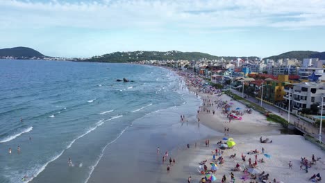 Aerial-view-of-Bombas-y-Bombinhas-full-of-tourists-and-panning-towards-sea