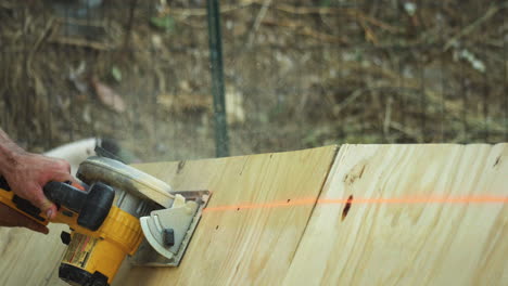 El-Hombre-Usa-Una-Sierra-Eléctrica-Para-Cortar-Rápidamente-El-Borde-De-Una-Gran-Pieza-De-Madera-Contrachapada