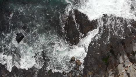 Luftaufnahme:-Wellen-Schlagen-Gegen-Felsige-Küste,-Rotierende-Drohnenansicht