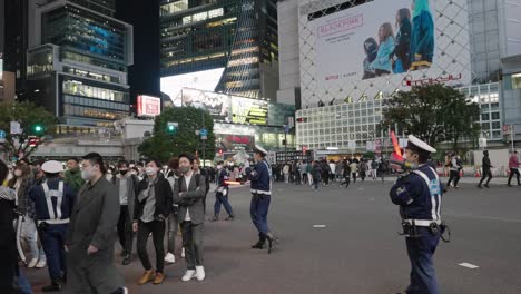 Oficiales-De-Policía-Con-Megáfono-Y-Bastón-De-Tráfico-Dirigido-Dirigiendo-Multitudes-En-El-Cruce-De-Shibuya-En-La-Noche-De-Halloween-En-Tokio,-Japón