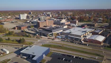Slow-colorful-aerial-shot-of-buildings-and-traffic-in-Muskegon,-MI