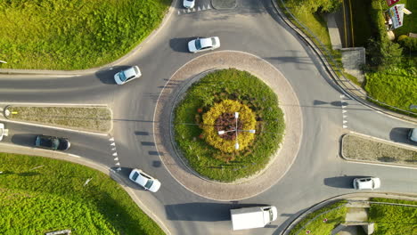 Vehicles-Driving-At-Roundabout-In-Lubawa,-Warmian-Masurian-Voivodeship,-Poland-On-A-Sunny-Morning---aerial-top-down