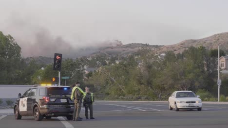 With-a-backdrop-of-the-Silverado-Wildfire,-Orange-County-Police-help-coordinate-evacuations-on-the-streets-in-the-city-of-Foothill-Ranch