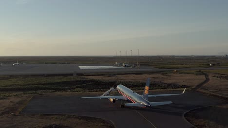 Circule-La-Antena-Panorámica-Alrededor-Del-Boeing-757-Durante-La-Hermosa-Luz-Del-Sol-En-El-Asfalto-De-Islandia