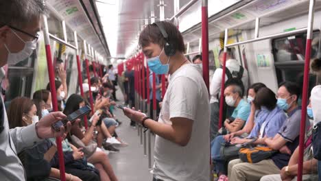 Pendler,-Die-Gesichtsmasken-Zur-Vorbeugung-Gegen-Das-Coronavirus-Tragen,-Das-Offiziell-Als-Covid-19-Bekannt-Ist,-Werden-In-Der-MTR-U-Bahn-In-Hongkong-Gesehen