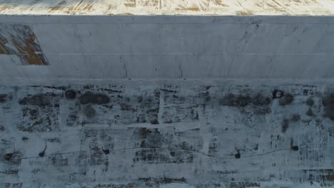 Aerial-of-rusty-old-factory-roof-with-man-in-red-shirt-climbing-on-slope