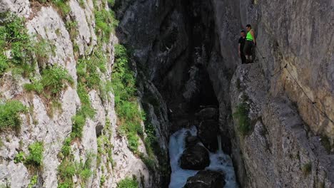 Atemberaubende-Drohnenansicht-Eines-Majestätischen-Und-Mächtigen-Wasserfalls,-Der-Durch-Felsen-Inmitten-Steiler-Waldberge-Fließt
