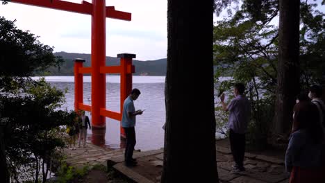Crowd-of-people-wearing-facemasks-gathered-at-Hakone-Shrine-Torii-gate-to-take-pictures