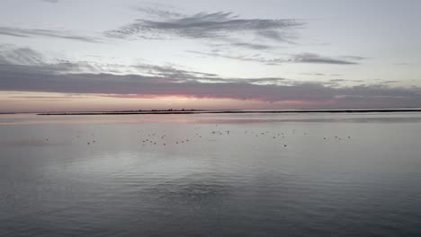 Atemberaubender-Sonnenuntergang-über-Dem-Meer,-Vögel-Fliegen-Aufs-Meer-Und-Das-Meer-Ist-Ruhig-Wie-Eine-Brise