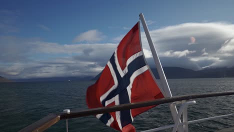 Barco-Navegando-Sobre-El-Mar-Con-La-Bandera-Noruega-Ondeando---Viaje-En-Barco-En-Finnkroken,-Troms,-Noruega---Primer-Plano,-Punto-De-Vista