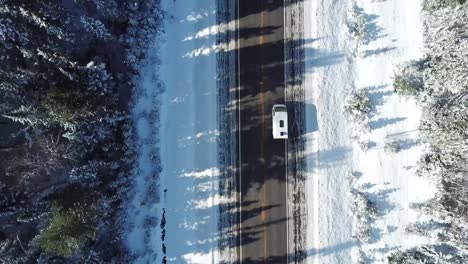 Van-driving-on-the-wintery-highways-of-Canada---camera-pan-up---Drone-4k-Aerial