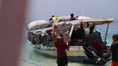 Indonesian-Men-Loading-Sacks-Of-Waste-Materials-For-Recycling-Into-A-Boat-In-Gili-Trawangan-Island---full-shot