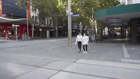 Las-Niñas-Caminan-Por-La-Ciudad-Vacía-De-Melbourne-Durante-El-Encierro-Covid-Mientras-Las-Restricciones-Del-Coronavirus-Se-Afianzan---Bourke-Street,-Melbourne,-Australia