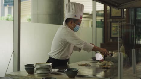 Teppanyaki-Chef-Cooking-Fried-Rice-With-Meat-And-Vegetables-On-Griddle