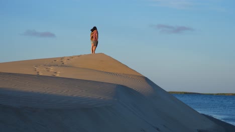 Eröffnungsaufnahme,-Paar-Steht-Auf-Dem-Gipfel-Des-Wüstenhügels-In-Adolfo-Lopez-Mateos-Baja-California-Sur,-Mexiko,-Sonnenaufgang-Im-Hintergrund