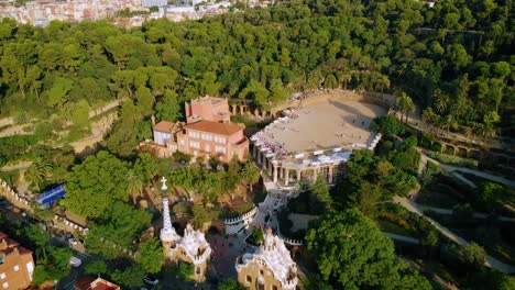 Aerial-view-of-the-Parc-Guell,-UNESCO-World-Heritage-Site,-in-Barcelona,-sunny-evening,-Spain---tilt-down,-drone-shot