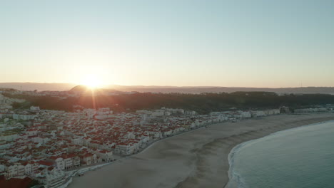 Panorama-Del-Paisaje-Urbano-En-El-Océano-Tranquilo-De-Praia-Do-Norte-En-Nazare,-Portugal-Durante-El-Amanecer