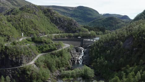 Aerial-ascending-shot-over-Dam-with-winding-roads-on-valley-of-Norwegian-Mountains