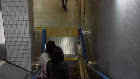 Mirando-Hacia-Abajo-A-La-Gente-Que-Viaja-En-Escaleras-Mecánicas-En-La-Ciudad-De-Tokio,-Japón