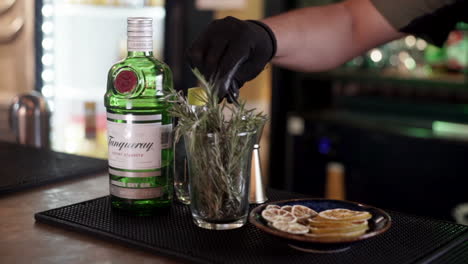 Bartender-preparing-dressing-with-rosemary-gin-tonic
