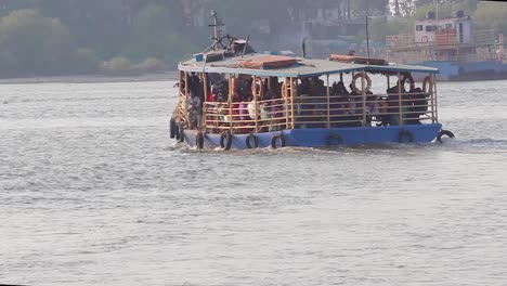 A-Small-Ferry-boat-full-of-passengers-moving-towards-shore-in-middle-of-the-bay-video-background-in-Full-HD