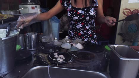 Vietnam,-Ciudad-Ho-Chi-Minh,-Una-Mujer-Está-Cocinando-Crepes-Vietnamitas-En-Un-Puesto-De-Comida-Callejera-Parte-Uno