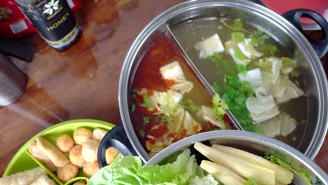 Gemüse-Mit-Einer-Zange-Pflücken-Und-In-Kochende-Tomyam-Hot-Pot-Suppe-Geben