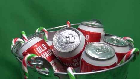 2-3-green-screen-looped-rotating-candy-canes-hanging-from-a-metalic-bucket-of-refreshing-sixer-of-an-old-milwaukee-canned-beer-iced-with-droplets-of-water-and-ready-to-be-quenched-for-the-festivities
