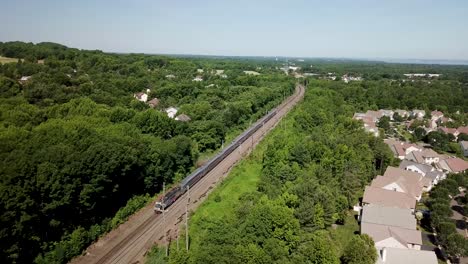 Aerial-footage-of-an-NJTransit-train-traveling-through-Holmdel,-New-Jersey