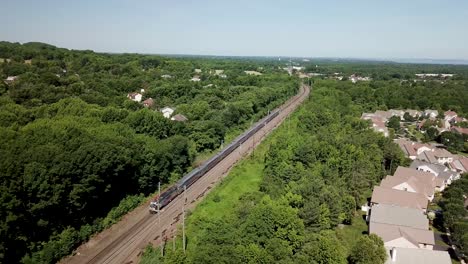 Aerial-footage-of-an-NJTransit-train-traveling-through-Holmdel,-New-Jersey