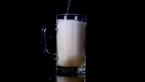 Slow-motion-shot-of-pouring-beer-in-a-mug-until-it-spills-over