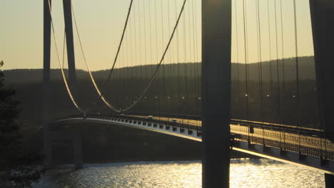 Cars-driving-over-a-bridge,-at-a-sunny-evening,-at-Hoga-Kusten,-Vasternorrland,-Sweden
