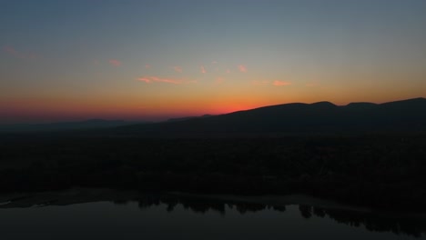 aerial-shot-of-a-sunset,-or-sunrise,-camera-slowly-descending-down