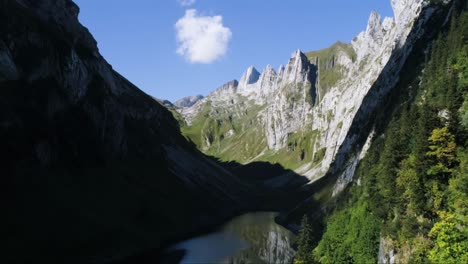 Luftdrohnenflug-Durch-Gebirgstal-Mit-Reflektierendem-See-In-Der-Schweiz