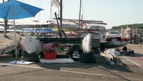 A-young-woman-cleaning-and-maintaining-a-catamaran-sailboat-on-the-docks-of-a-harbor-in-France