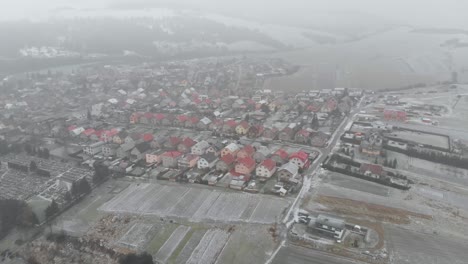 Aerial-forward-towards-snow-covered-residential-houses-in-suburb-during-snow-storm