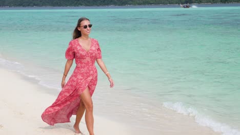 Ultra-slow-motion-shot-of-tanned-caucasian-woman-with-pink-dress-walking-on-beautiful-beach-on-island-in-Thailand