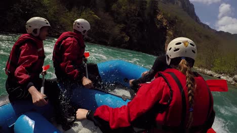 Women-smiling-while-rafting-on-river-and-splash-into-the-raft