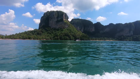 Longtail-Bootsansicht-Der-Klippen-Von-Railay,-Thailand,-Asien-Mit-Wunderschönem-Meer-Im-Vordergrund-Und-Einem-Vorbeifahrenden-Boot-Unterhalb-Der-Klippen-–-Gefilmt-Mit-120-Bildern-Pro-Sekunde-2