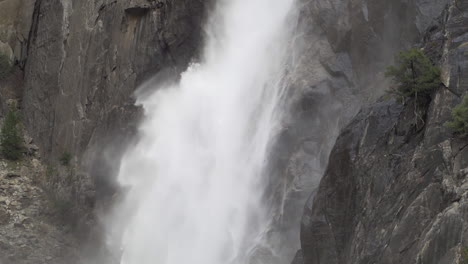 Close-up-slow-motion-shot-of-lower-Yosemite-falls-in-early-spring,-snow-melt-runoff-creating-large-waterfall-and-mist