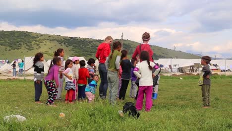 Voluntarios-Bailando-Con-Niños-Refugiados-En-El-Campo-De-Refugiados-De-Katsikas,-Grecia,-Mayo-De-2016