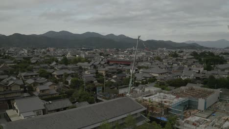 Aerial-Drone-Shot-of-Kyoto-at-Sunset-near-a-river,-Japan,-Asia