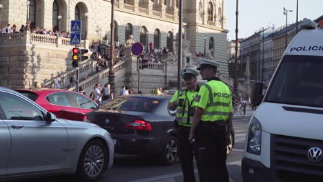 Oficiales-De-Policía-Parados-En-La-Calle-Praga-Llena-De-Autos