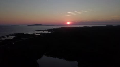Drone-slowly-flying-up-facing-sunset-and-horizon-over-the-Atlantic-Ocean-in-Nova-Scotia-in-Canada
